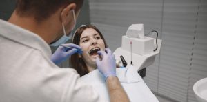 Pasien wanita duduk di kursi gigi saat dokter gigi bekerja e
